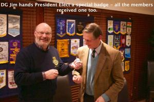DG Jim made badges for all the club members. Photo shows SVP Malcolm Ross being presented with his one.